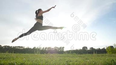 运动和健康的生活方式理念.. 年轻的运动女子在跳远阳光的天空背景下
